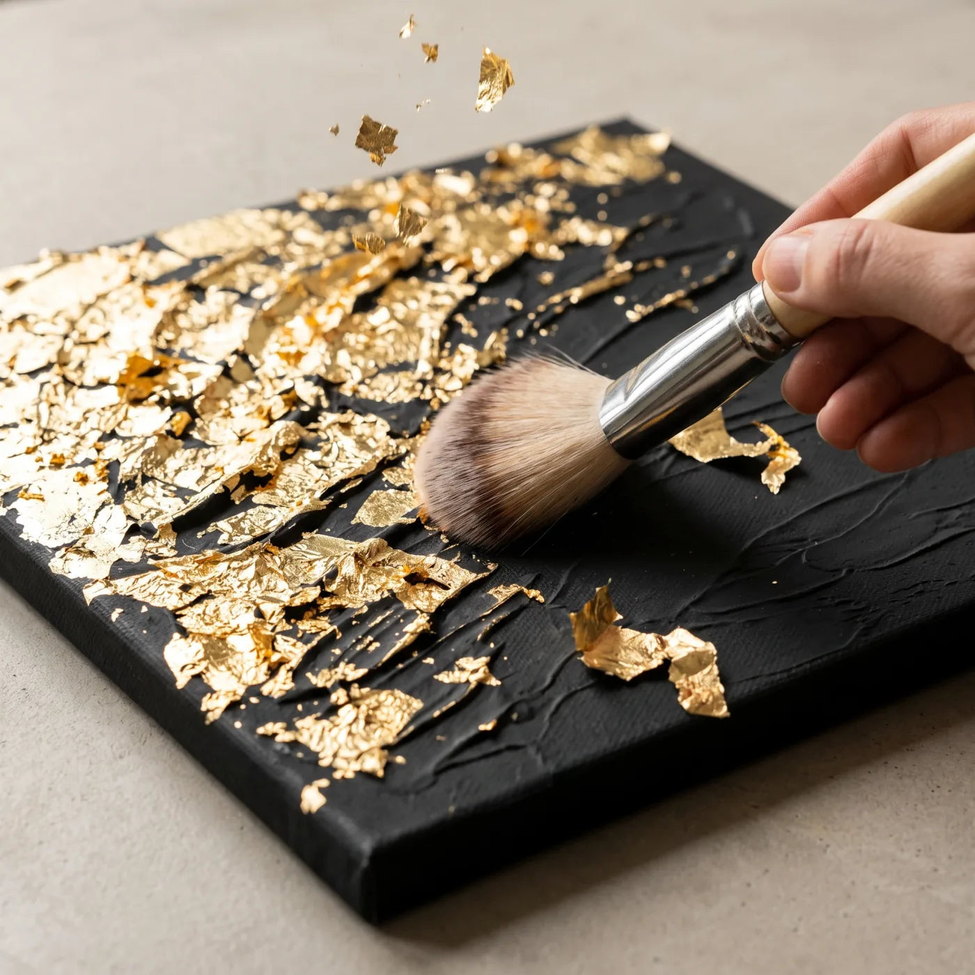 Spazzolatura dell'eccesso di foglia d'oro con pennello morbido dal rilievo dorato