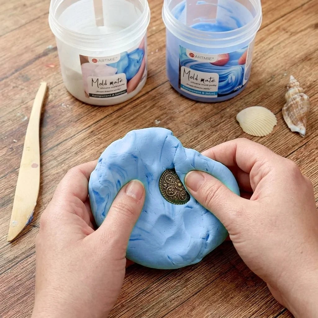 Impronta di una medaglia nella pasta siliconica ARTMIE Mold Mate miscelata sul banco da lavoro
